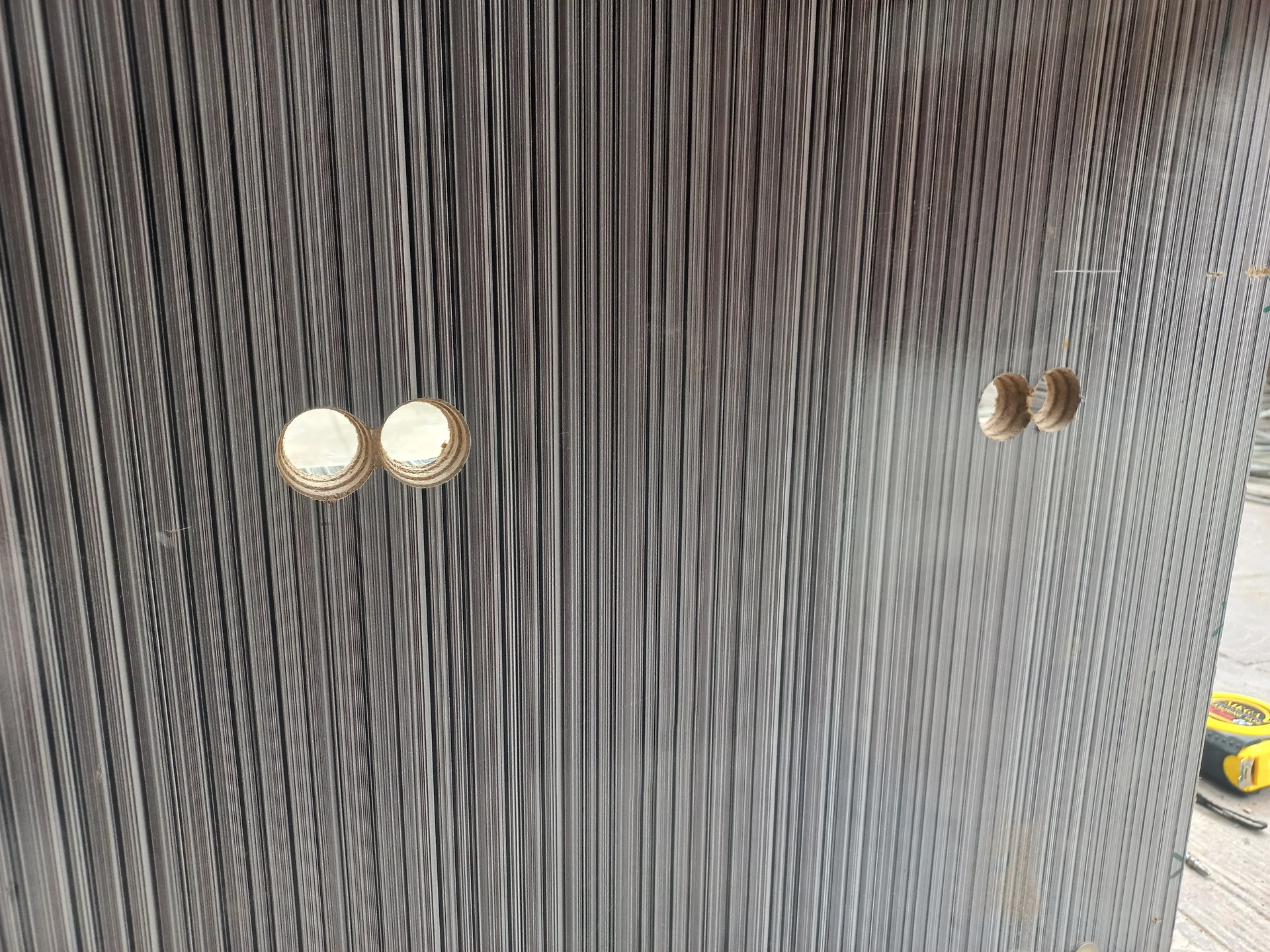 Multiple sensor holes drilled across the bin wall panels, showing the raw openings across two compartment faces