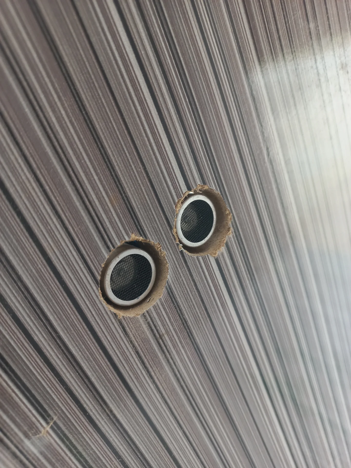 Two HC-SR04 ultrasonic sensor mounting holes in the bin wall, with the sensors inserted and viewed straight-on