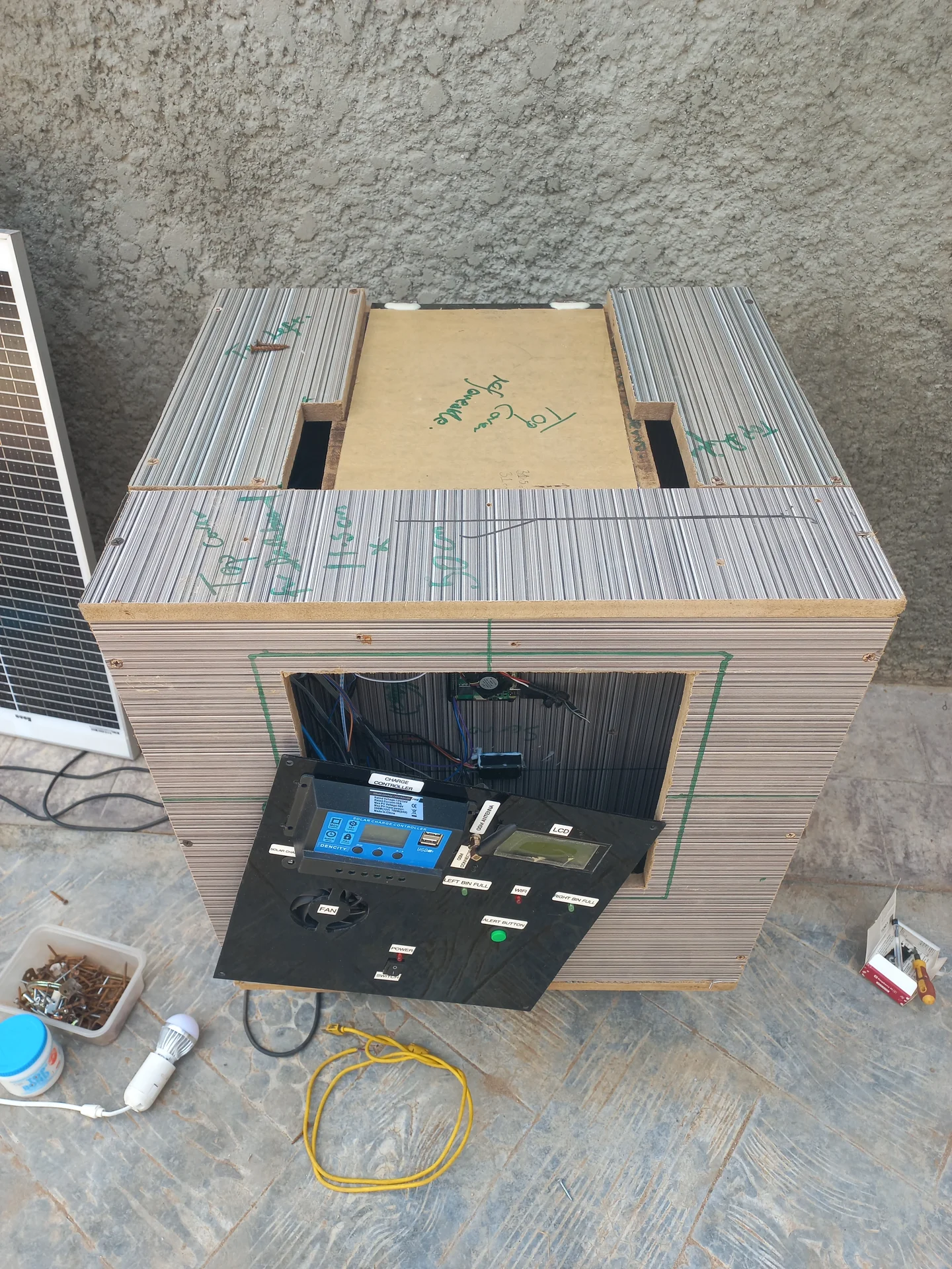 Front elevated view showing the top of the bin with marker annotations and the open electronics bay below, with the charge controller, LCD, fan and other components installed