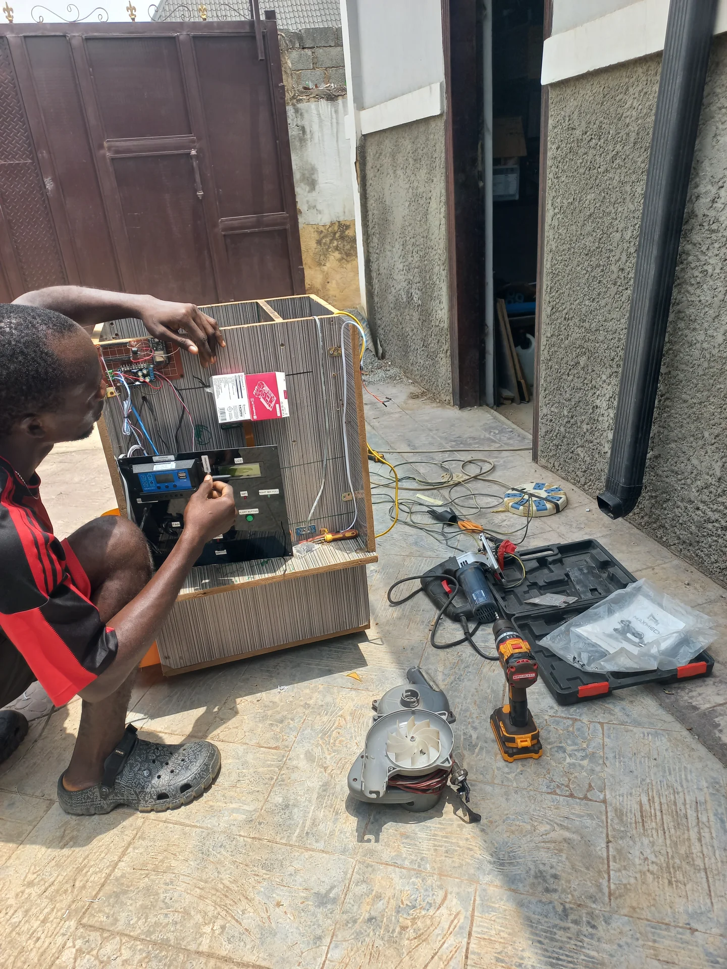 Builder leaning into the open electronics bay, running wires and making connections