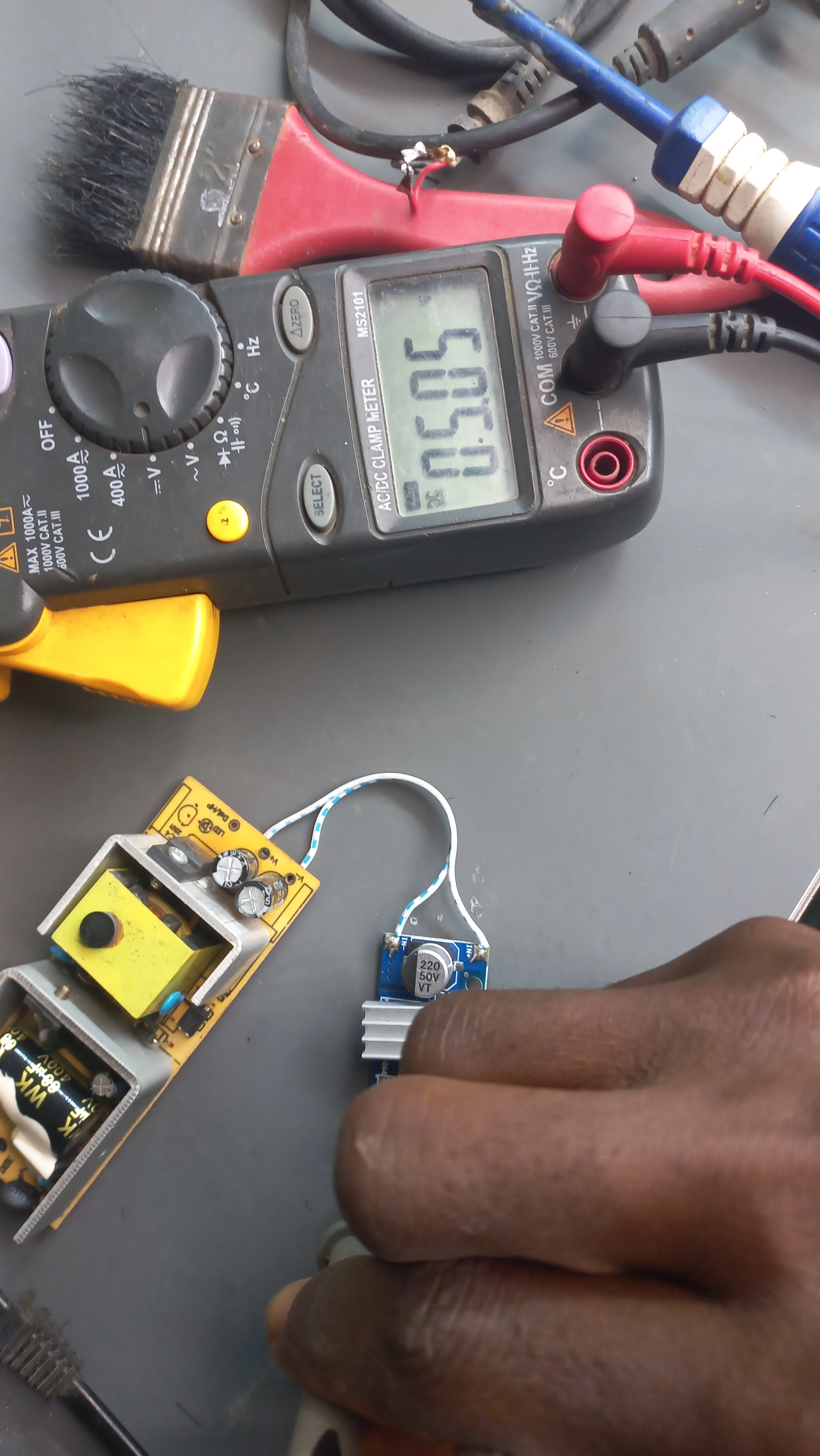 Multimeter verifying regulated 5 V output from buck converter — reading 1
