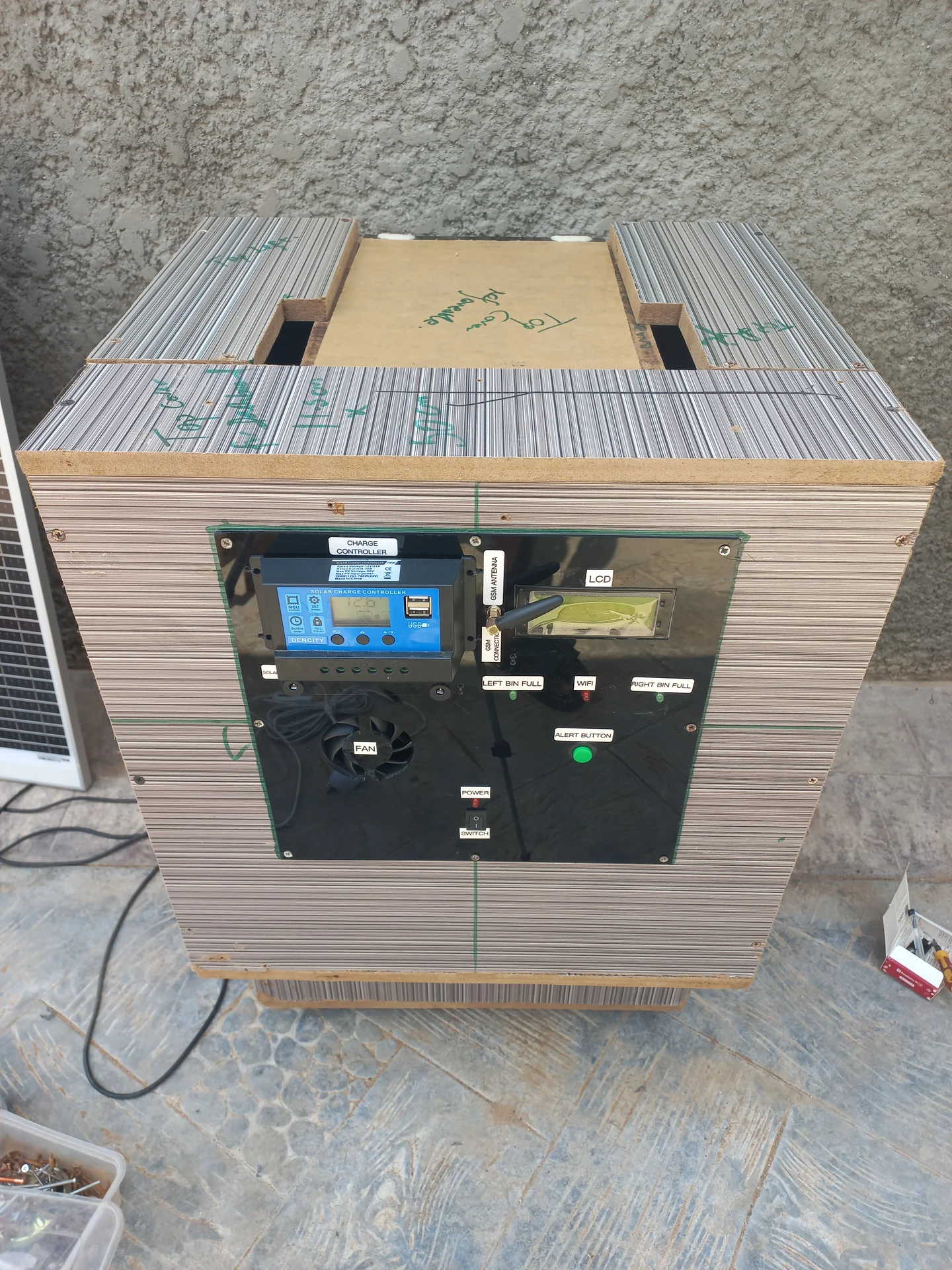 Front view of the enclosed bin showing the electronics panel with labels including CHARGE CONTROLLER, LCD, LEFT BIN FULL, WIFI, RIGHT BIN FULL, FAN and ALERT BUTTON