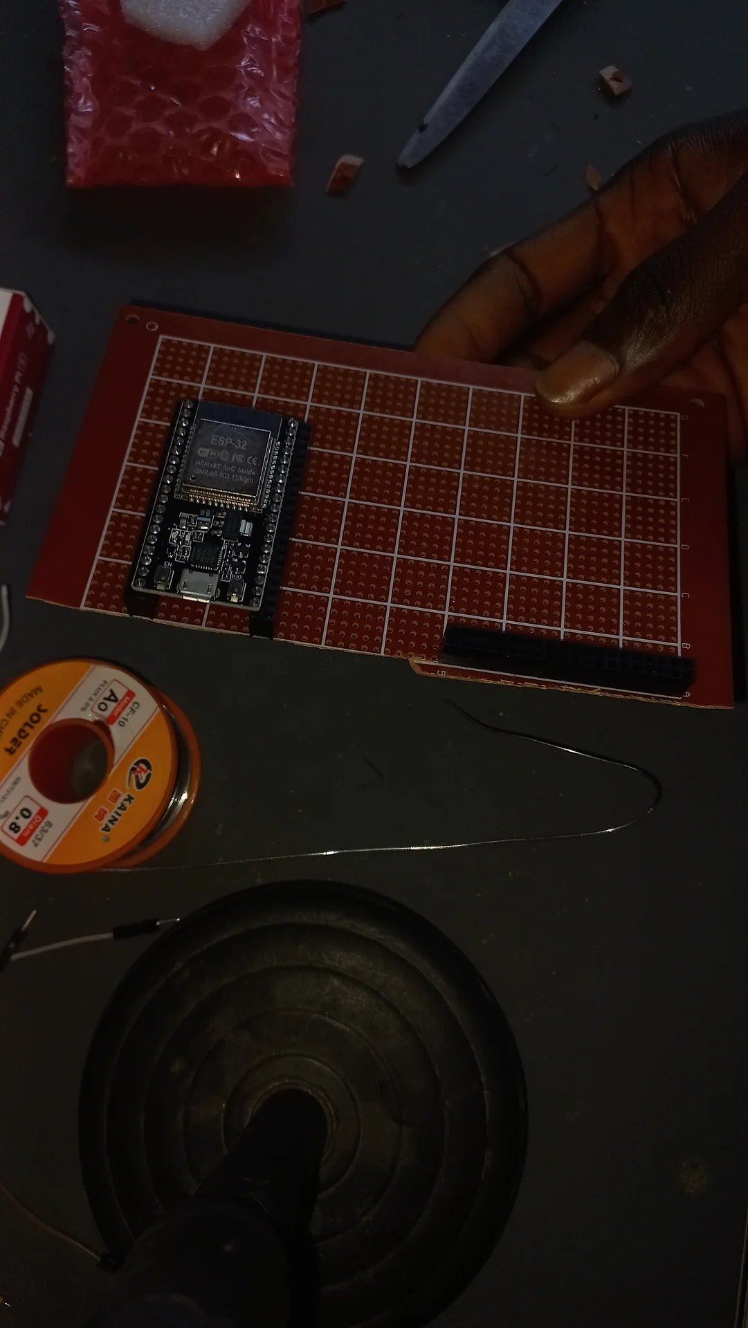 ESP32 placed on a perfboard at the very start of prototyping, with solder wire nearby but no connections yet made