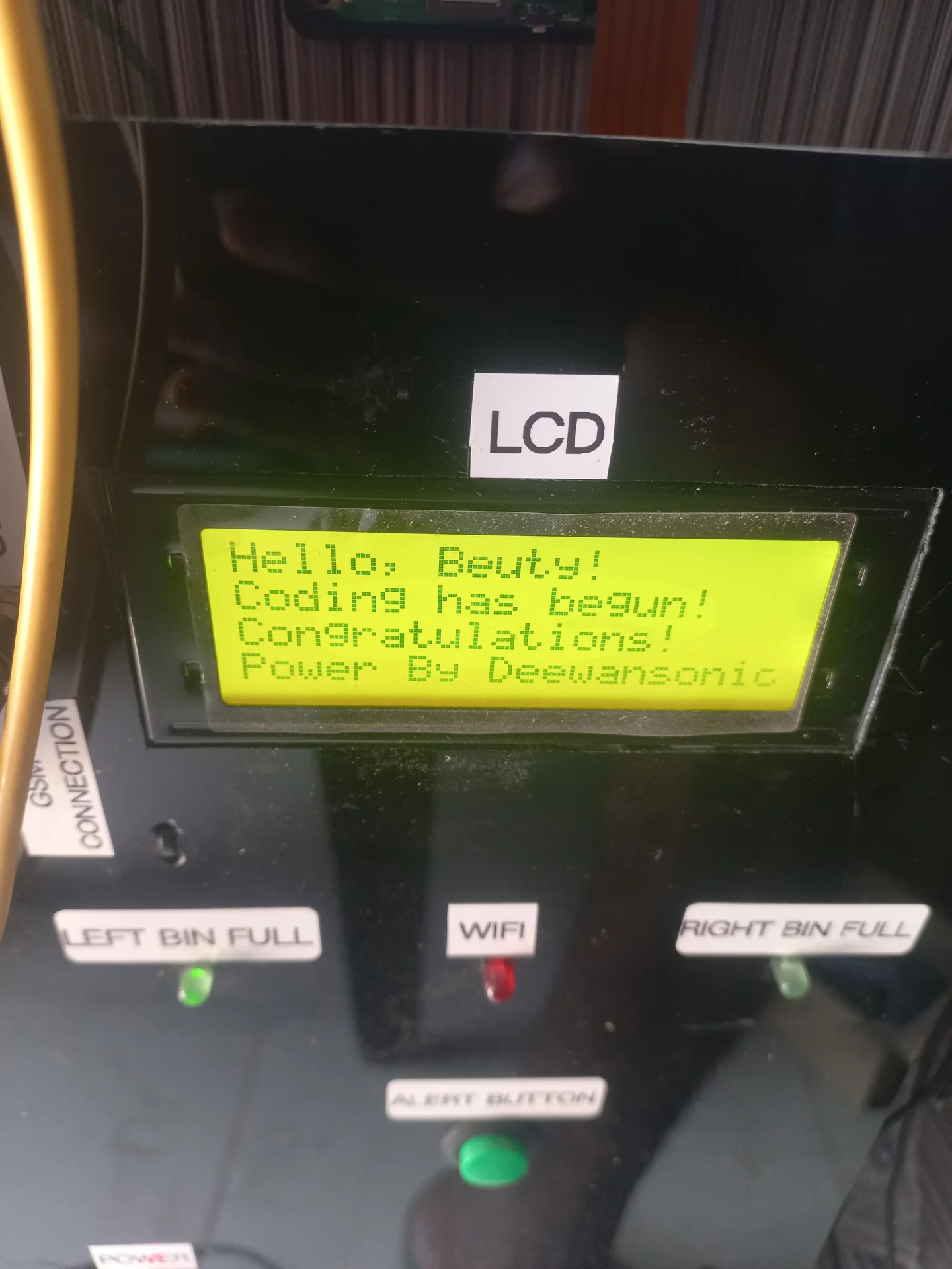 First boot of the LCD on the finished control panel. It shows the custom startup message: Hello, Beuty! Coding has begun! Congratulations! Power By Deewansonic