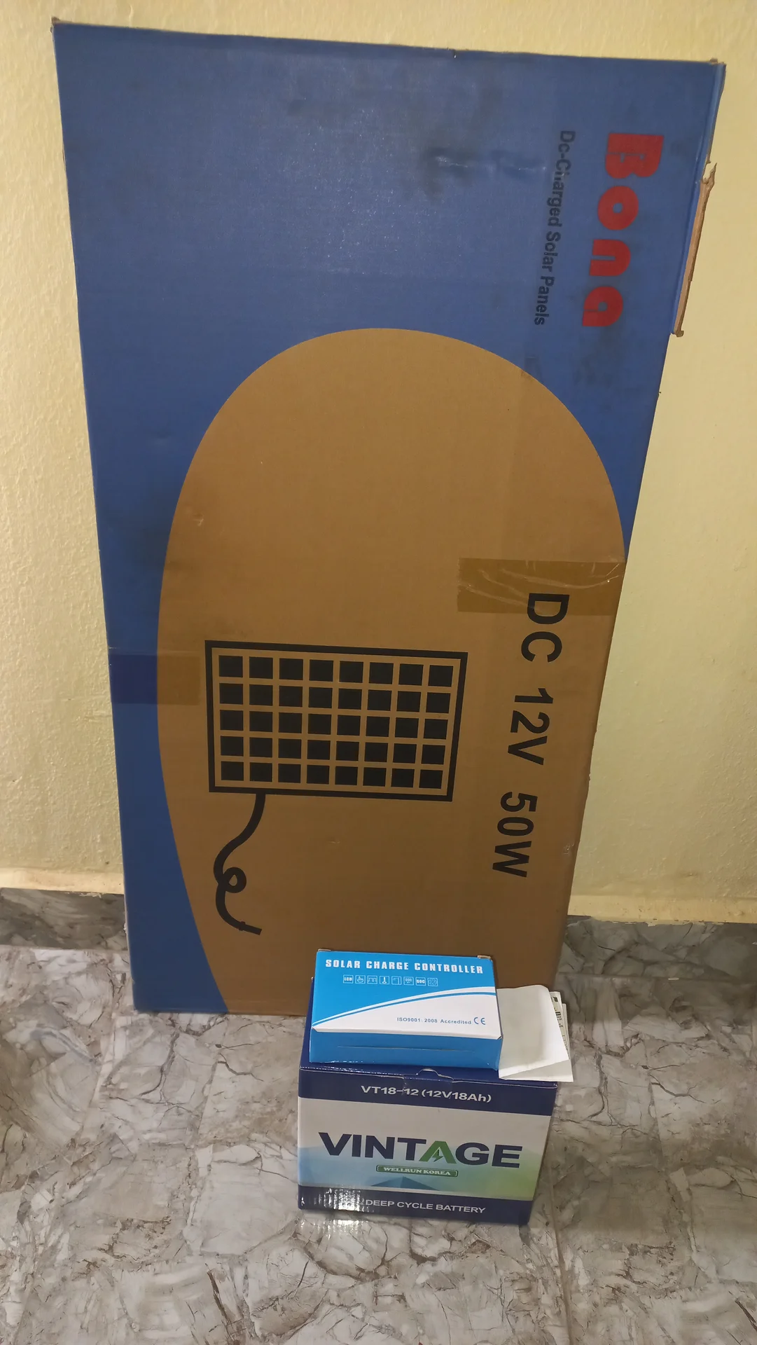 Overview of delivered components: the Bona DC 12V 50W solar panel box, the solar charge controller box and the VINTAGE battery box, before unpacking