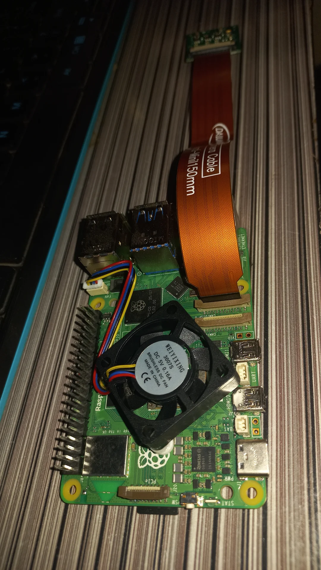 Pi 5 with the camera ribbon cable plugged into the CSI port, confirming the physical connection before software testing