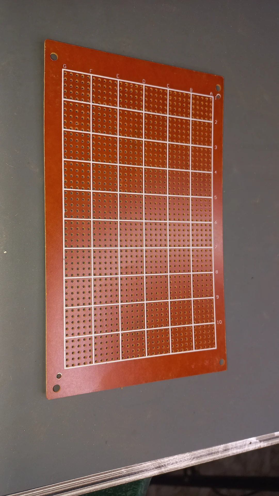Large perfboard showing the grid of drilled holes, used as the base for the circuit assembly