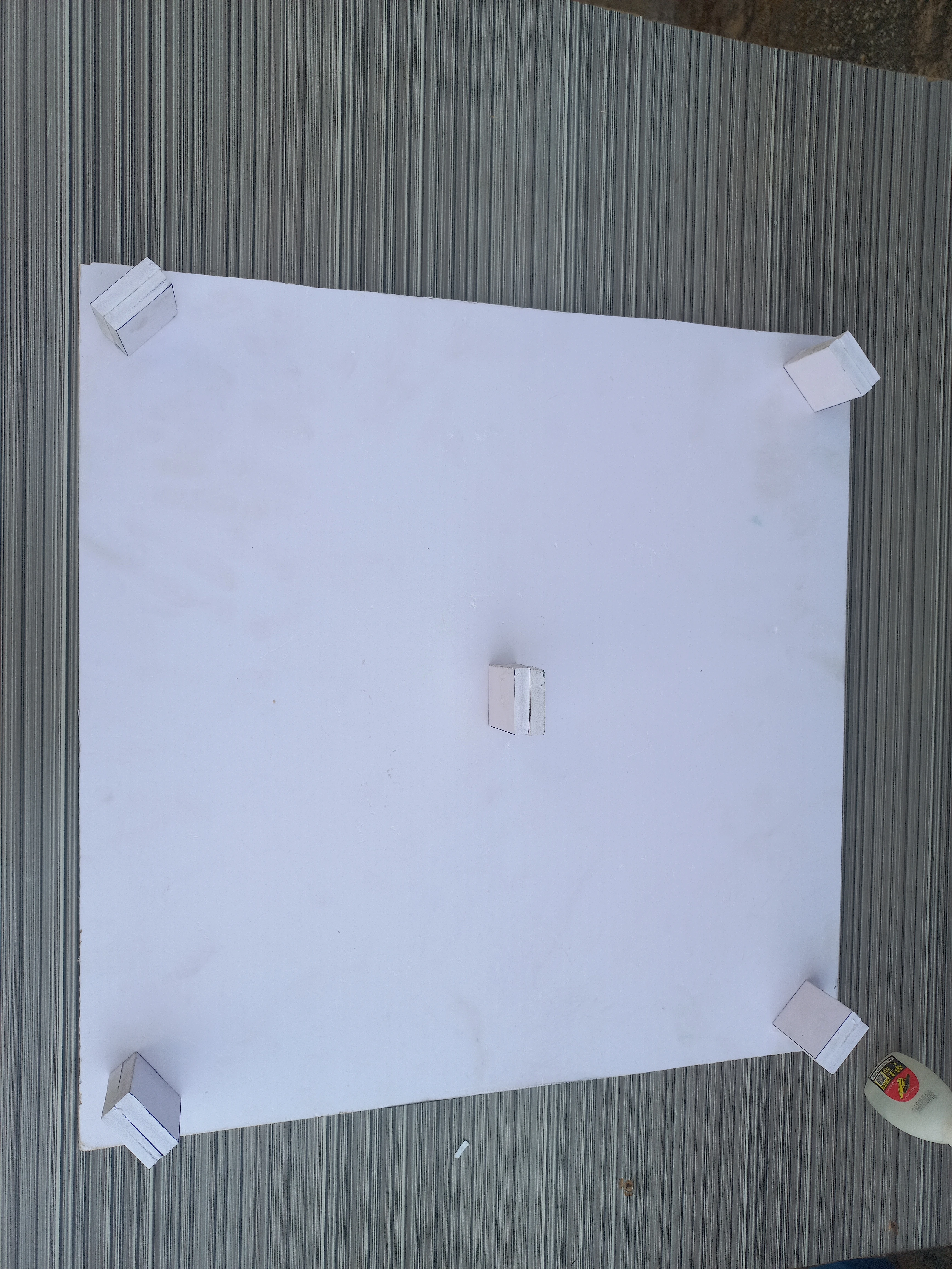 Underside of base board showing small wooden leg blocks glued at the corners for elevation