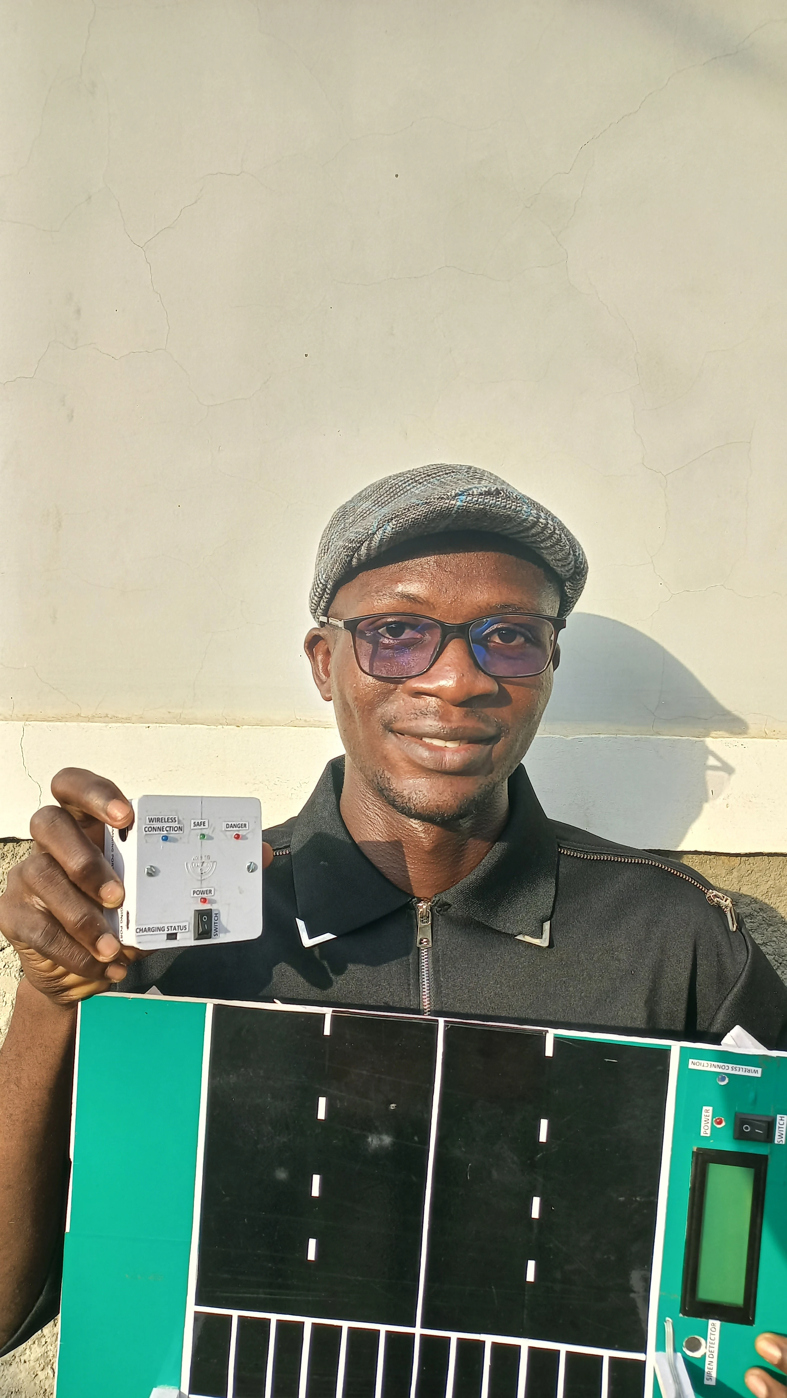 Developer holding the completed wearable unit showing the front panel with LED indicators