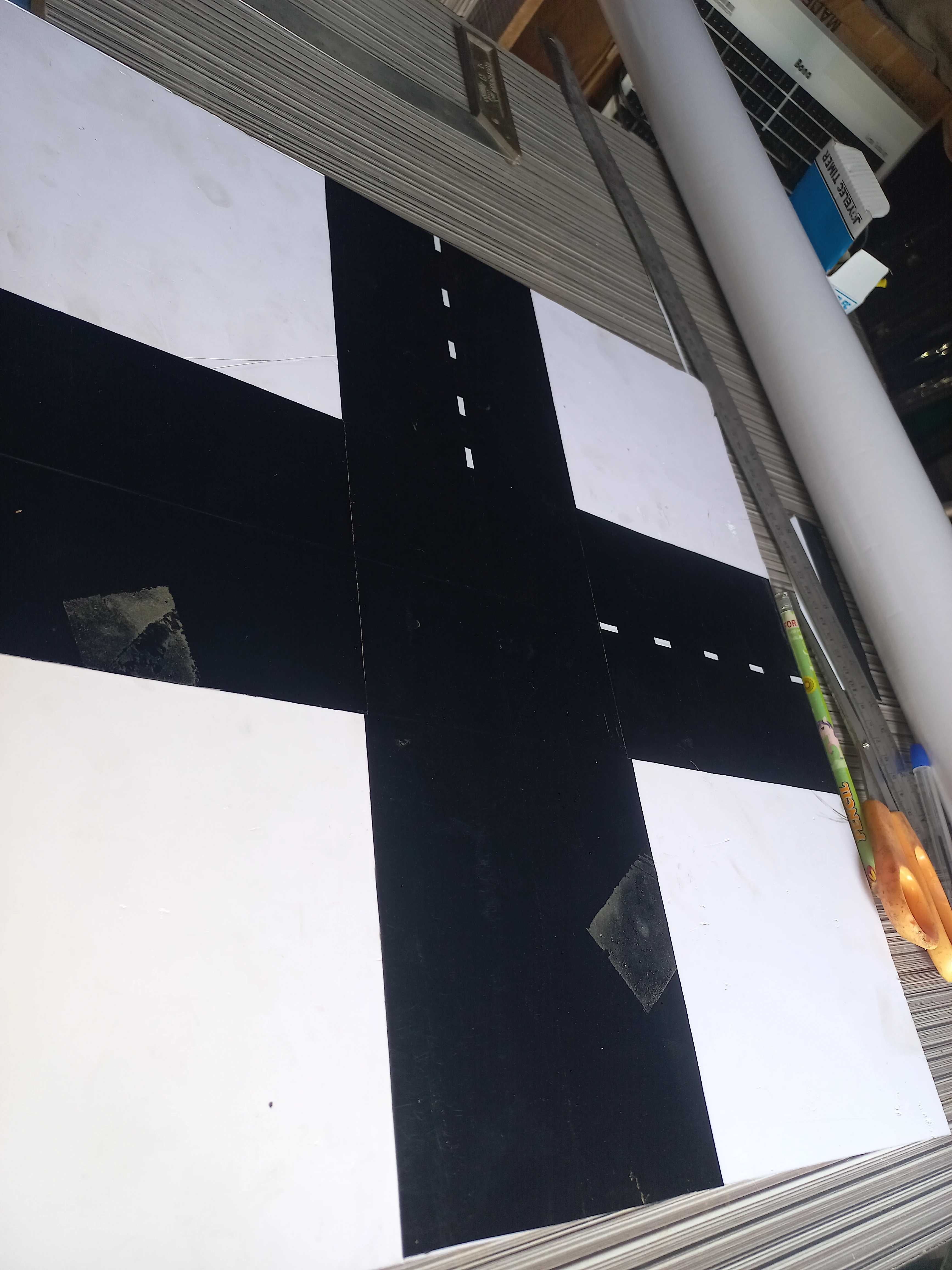 White dashed centre-line markings applied to two arms of the crossroads