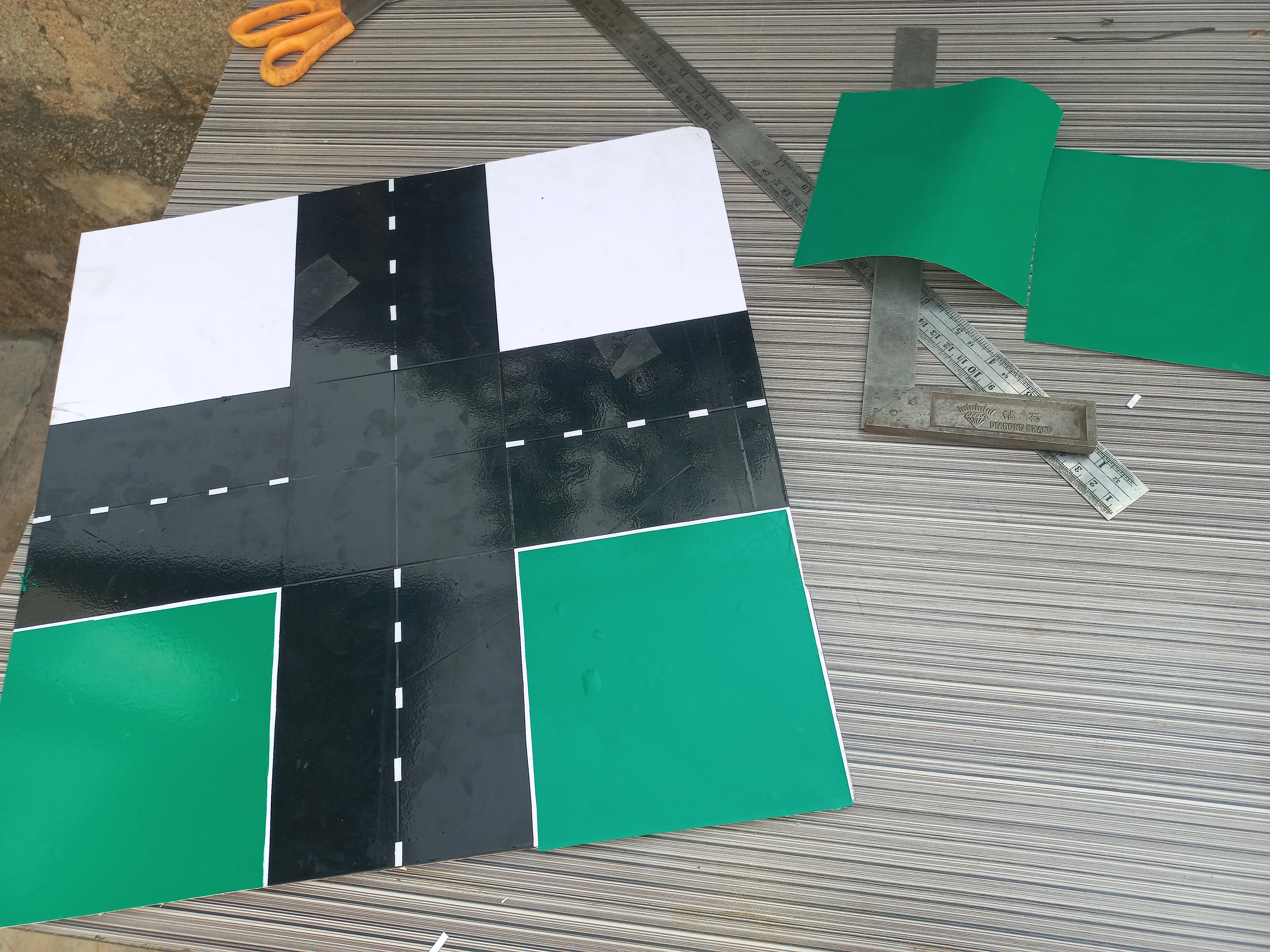 Road model with green vinyl applied to two corner areas; the two remaining corners still white