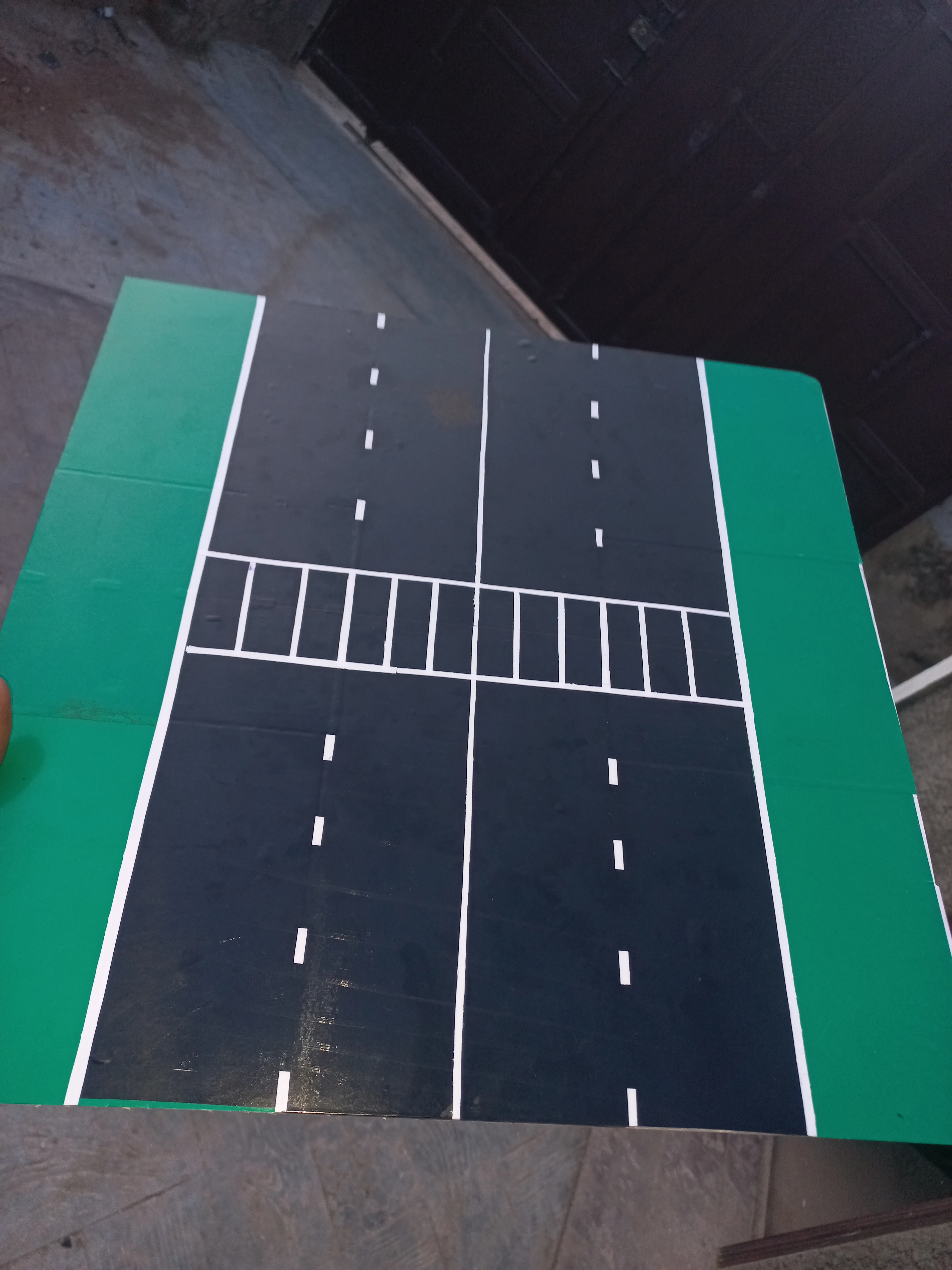Completed road model with white zebra pedestrian crossing strips applied across one arm