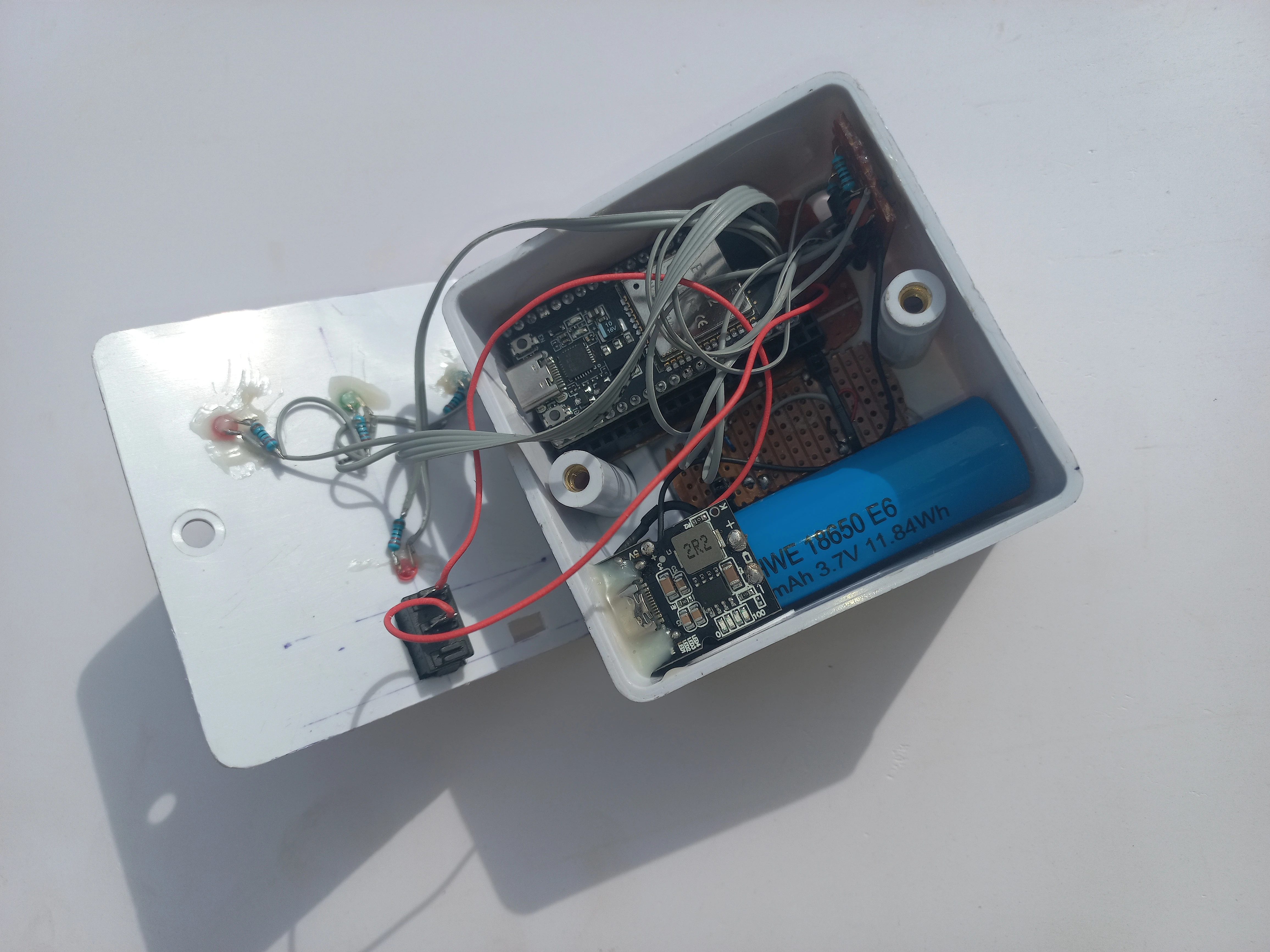 Wearable unit enclosure open showing the ESP32 board, TP4056 charger module, and 18650 battery inside